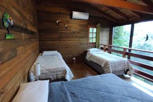 Alquiler Vacacional - Cozy wooden chalet with glass walls overlooking nature.