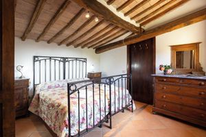 Alquiler Vacacional - Attic room with exposed beams, rustic Tuscan style