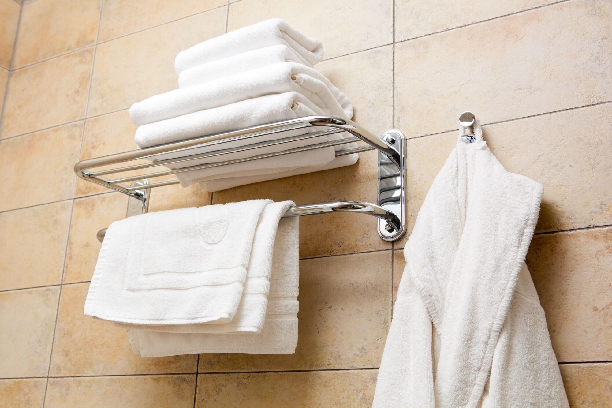 Сколько нужно полотенец. Ванная полотенца. Полотенца в гостиничном номере. Полотенце в ванной отель. Полотенца и халаты в ванной комнате.
